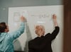 un homme et une femme dessinant un diagramme au tableau