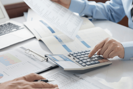 Personne réalisant des calculs et remplissant son tableau de bord