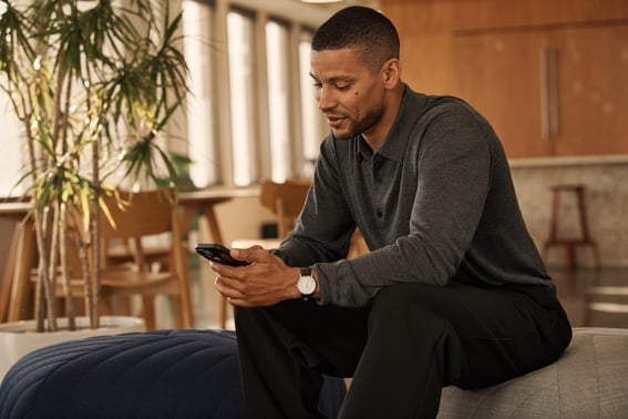Man office lounge typing on phone