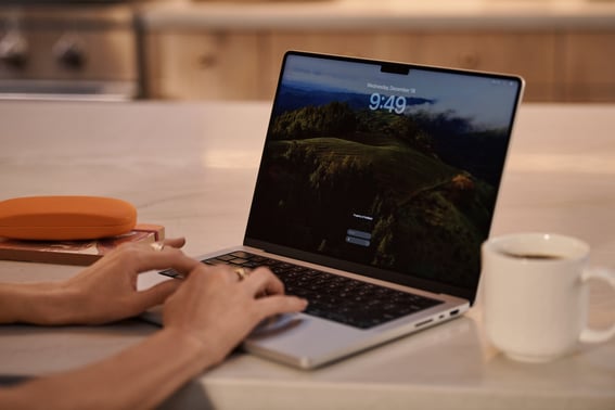 OTS woman typing laptop kitchen counter