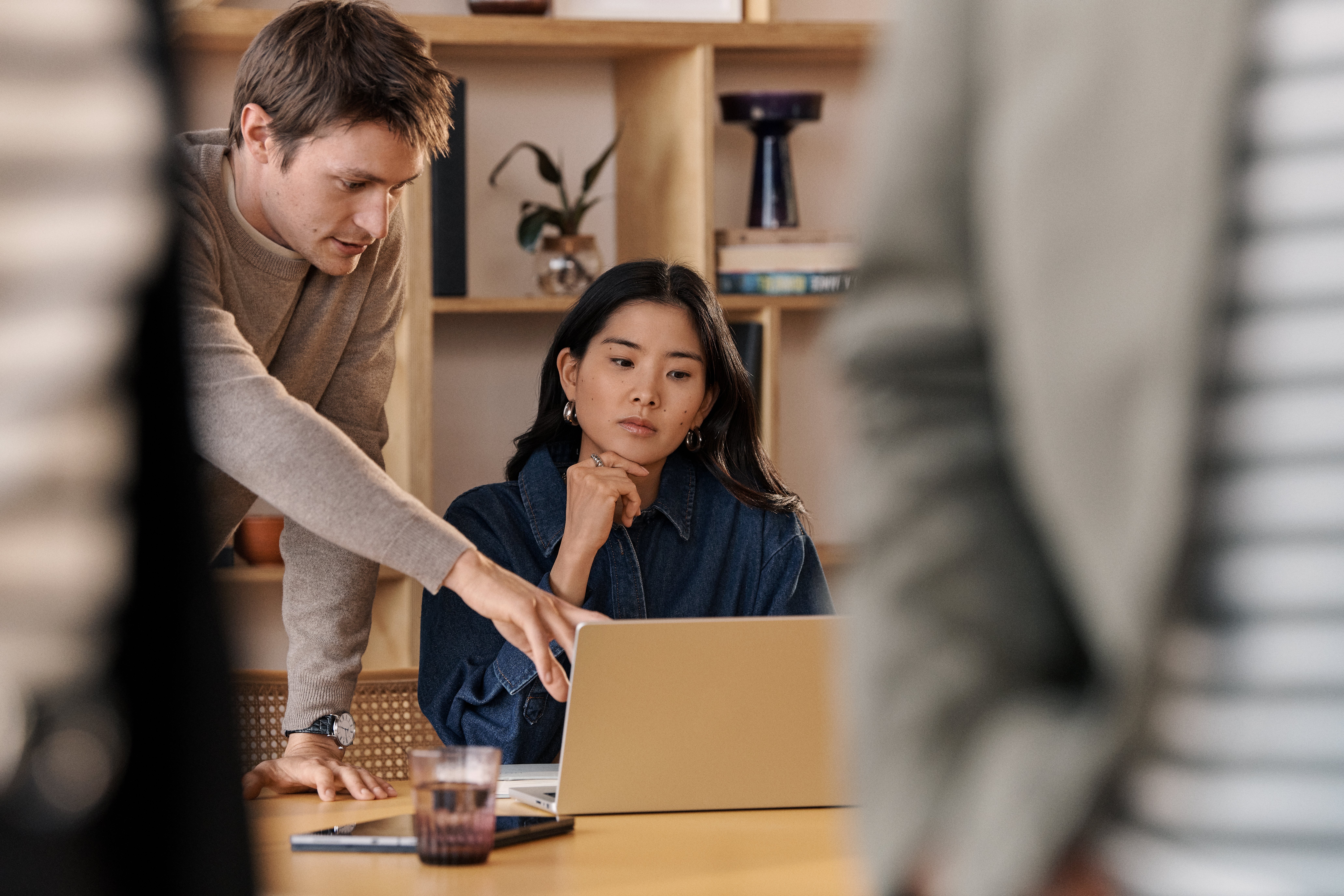 Woman laptop  man pointing  group in conference room
