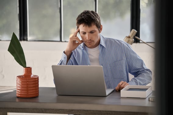Man in office with laptop and vase