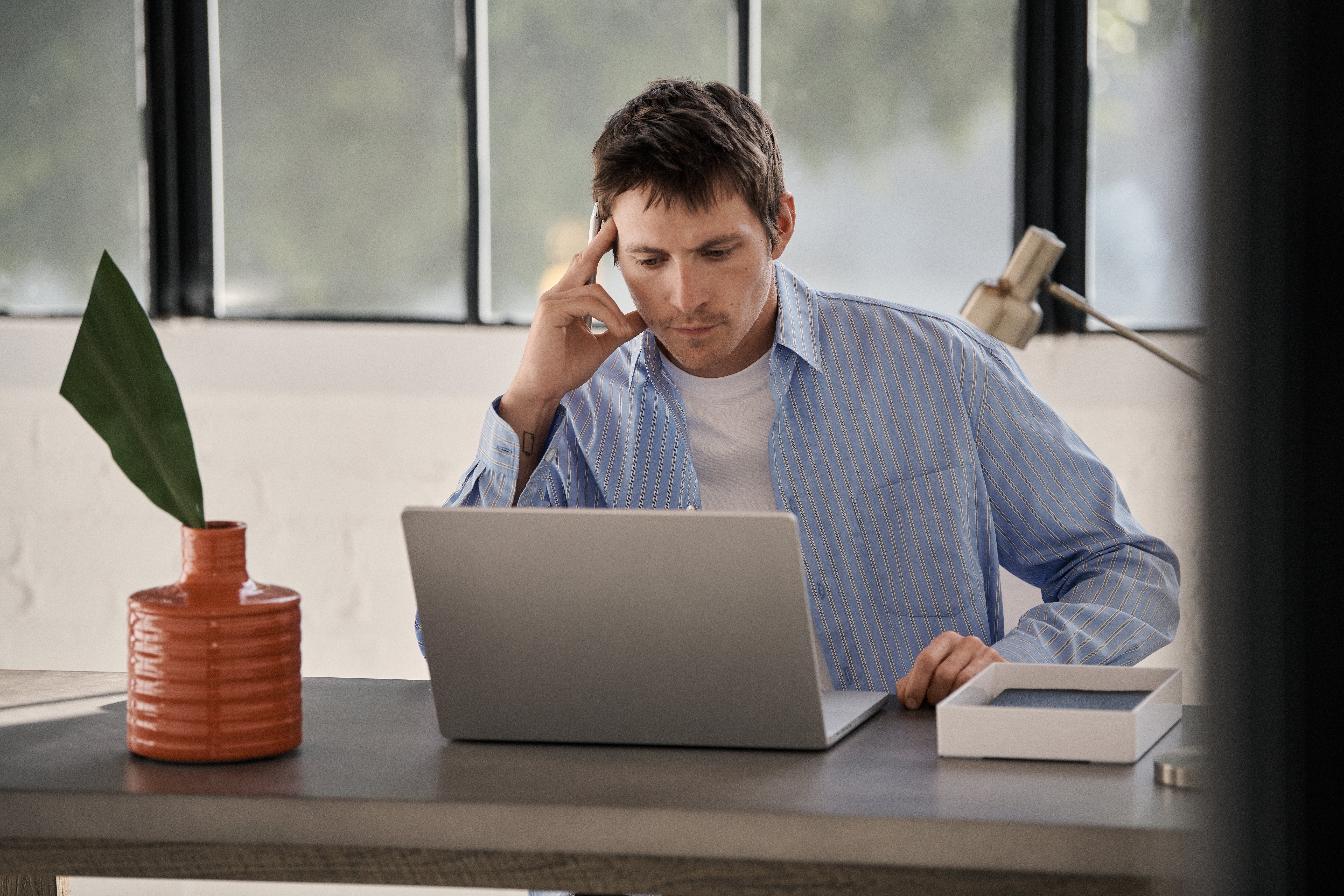Man in office with laptop and vase