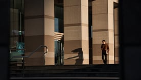 Wide shot man walking outdoors with phone