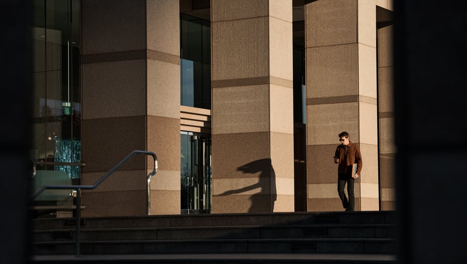 Wide shot man walking outdoors with phone