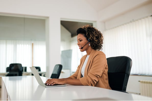 Sales woman at her computer researching prospects to cold call 