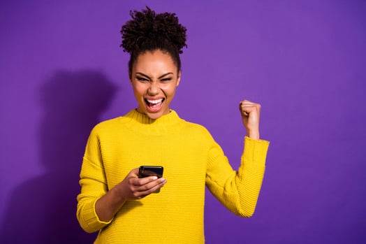 pessoa lê sobre como engajar seus followers no Instagram e faz pose vitoriosa