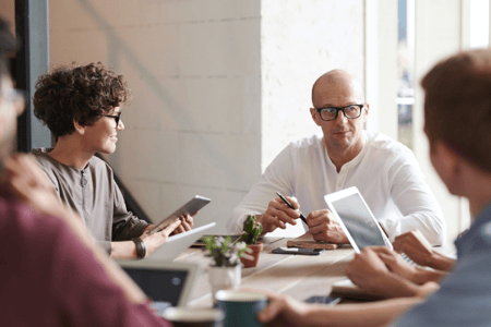 Collaborateurs échangeant en réunion autour d'une table
