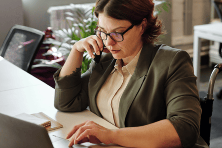 Commerciale au téléphone, assise à son bureau 