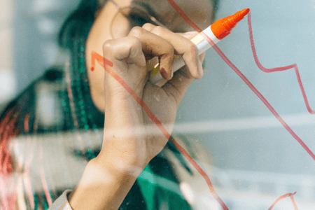 Personne entrain de dessiner au feutre sur une vitre
