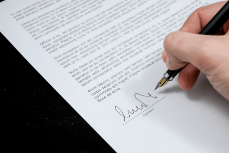 personne entrain de signer une lettre