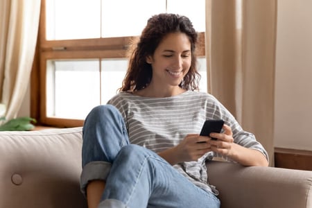 Frau sitzt auf einem Sofa und sucht auf instagram