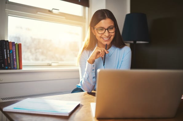 Frau sitzt am Laptop und sucht ein Joomla Template aus