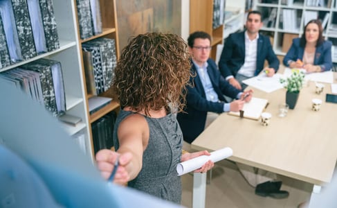 Frau erklärt Lasten- und Pflichtenheft im Projektmanagement