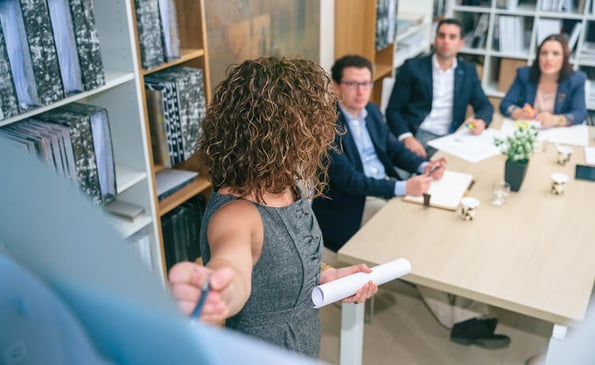 Frau erklärt Lasten- und Pflichtenheft im Projektmanagement