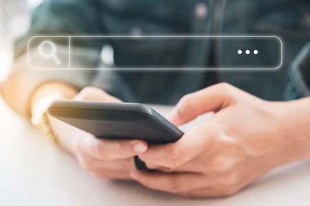 Person nutzt Metasuchmaschine auf Smartphone