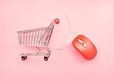 Einkaufswagen-mit-Maus-vor-farbigem-Hintergrund
