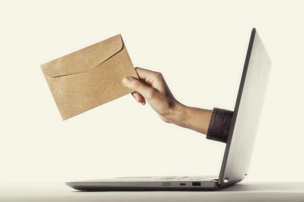 Hand ragt aus einem Laptop heraus und hält einen Umschlag