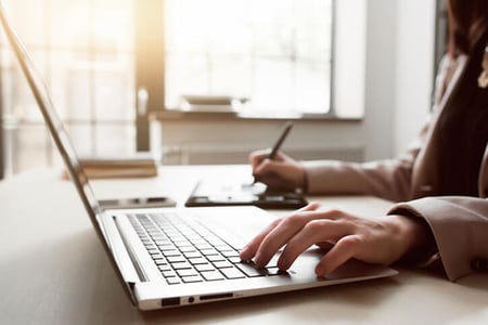 Frau nutzt Marketing-Reporting-Tool am Laptop