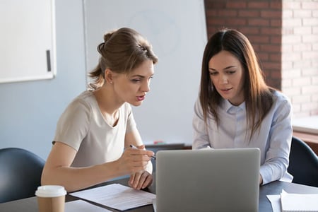 Zwei Kolleginnen besprechen Sales-Intelligence-Softwarelösung