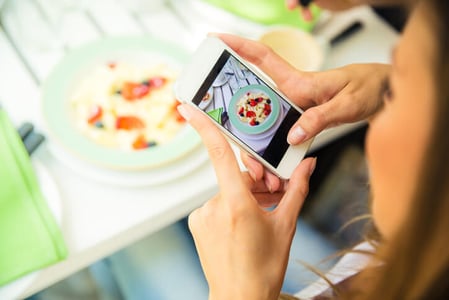 Frau fotografiert mit Smartphone