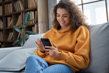 Frau schaut sich erfolgreiche Social-Media-Kampagne auf Smartphone an