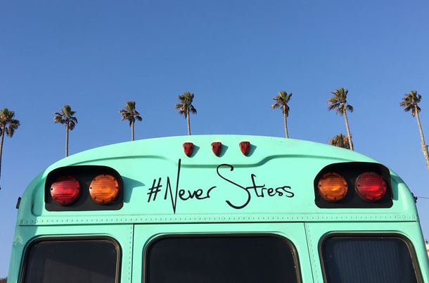 Mintgrüner Bus mit Schriftzug #Never Stress