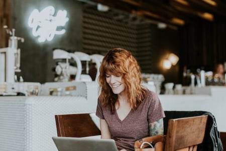 Frau arbeitet am Laptop und beantragt blauen Haken von Instagram
