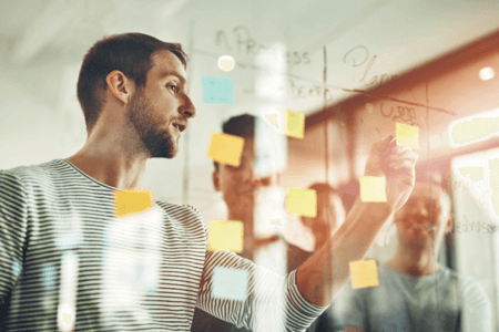 Business Development Team arbeitet zusammen an Glaswand