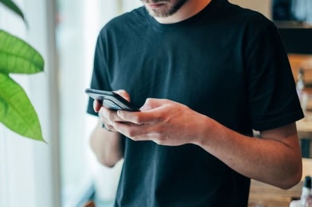 Mann beschäftigt sich mit Co-Autor-Funktion bei Instagram auf Smartphone