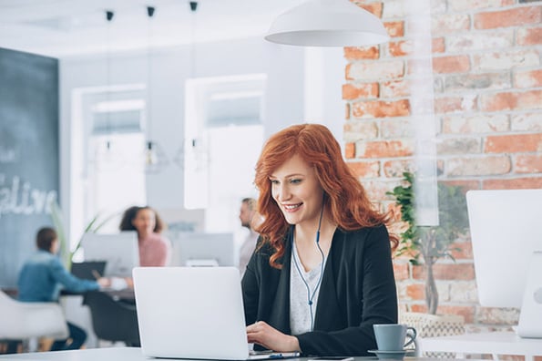 Frau sitzt vor Laptop und betreibt Community Management