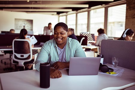 Mann im Büro spricht mit Deep Learning Sprachassistent