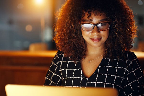 Frau mit Brille bei Nacht vor Laptop implementiert einfache SEO-Tipps