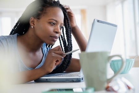 Frau sitzt am Laptop und schaut sich den E-Mail-Header an