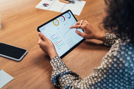 Mitarbeiterin ueberprueft am Tablet die Daten in ERP- und CRM-Systemen
