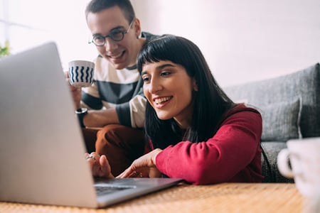 Paar zuhause vor Laptop schaut sich Gated Content an