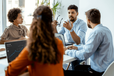 Team sitzt am Tisch und bespricht Marketing für Handwerksfirma