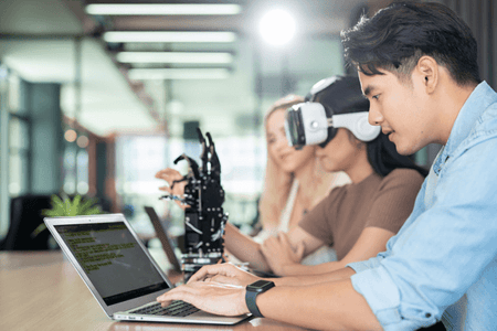 Frauen und Männer beschäftigen sich mit Vor- und Nachteilen künstlicher Intelligenz am Laptop