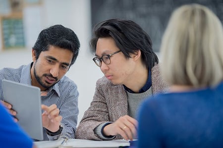 Zwei Männer vor Laptop diskutieren über Linkbait 