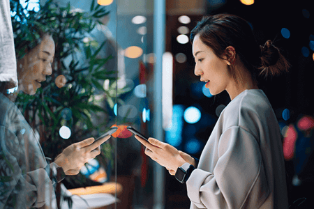 Asiatische Frau erstellt LinkedIn Ads auf Smartphone