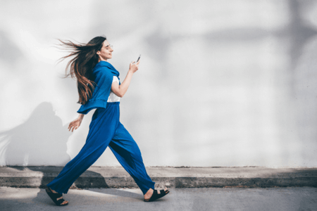 Schnell laufende Frau mit Smartphone in der Hand symbolisierend für Pagespeed