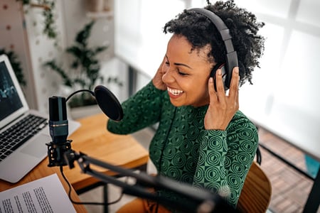 Frau nimmt am Mikrofon Podcast auf