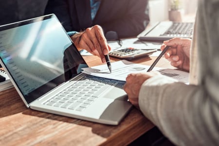 Personen erstellen Projektbericht mit Stift, Papier und Laptop