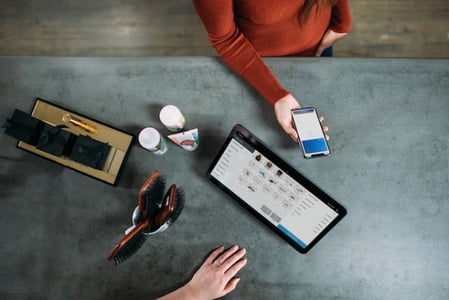 Kundin bezahlt fuer den Einkauf als Symbol fuer Retention Rate