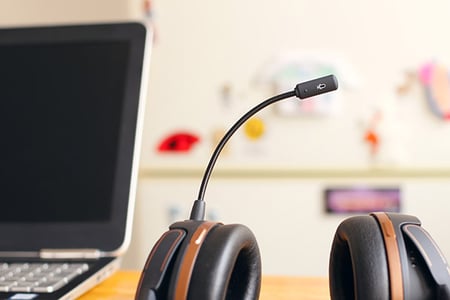 Customer Self-Service symbolisiert durch Headphones neben Laptop auf Tisch