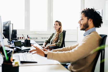 Mitarbeitende im Servicedesk und Helpdesk am Tisch unterhalten sich