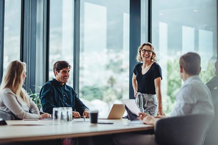 Team macht Stakeholderanalyse bei Meeting in Buero und lacht wild