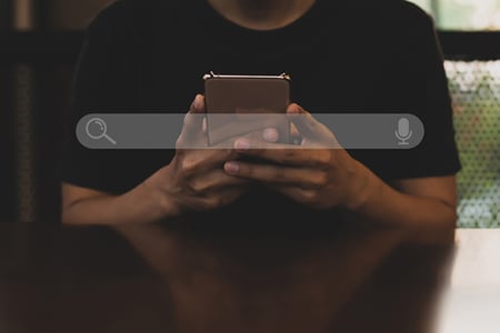 Mann betreibt Suchmaschinenmarketing am Handy