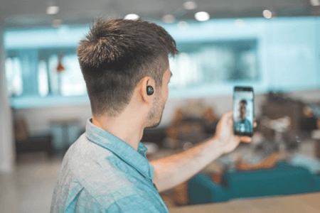 Mann nimmt TikTok Video mit dem Smartphone auf, um Geld zu verdienen