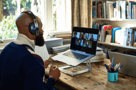 Mann vor Laptop nimmt an Webinar über Webinar-Software teil